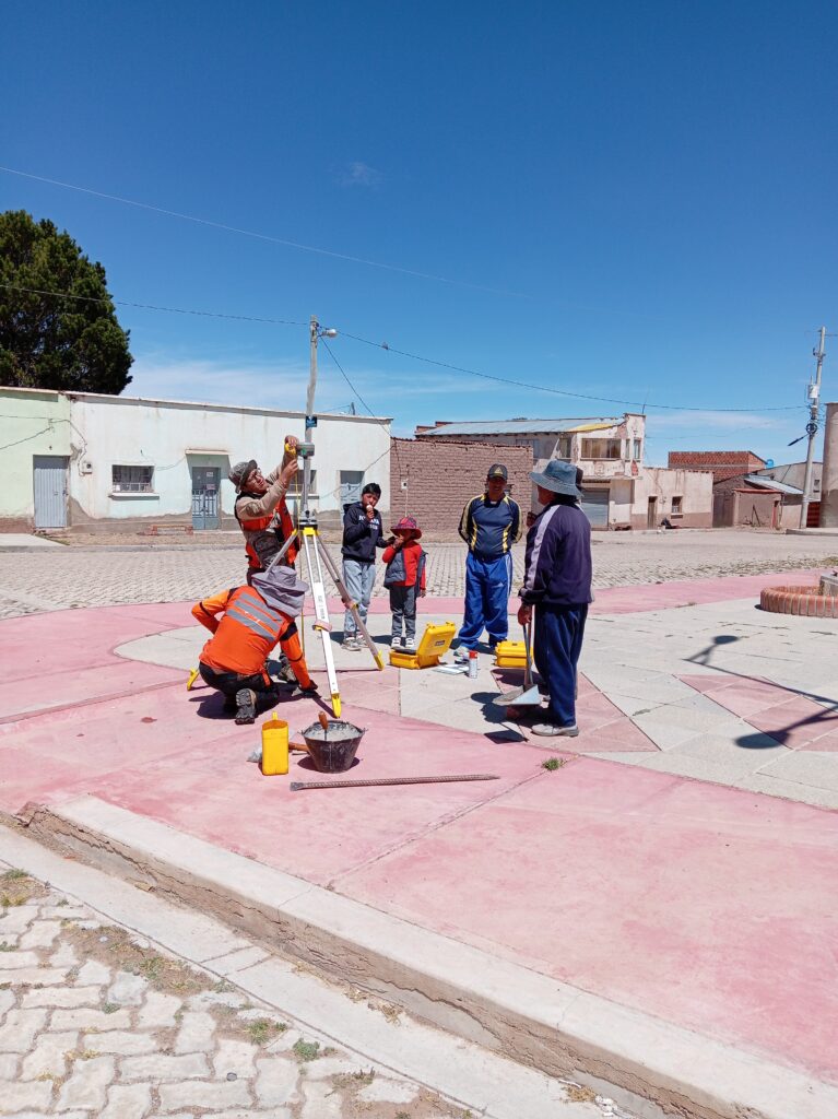 Equipo de topografía realizando replanteo y control en una plaza